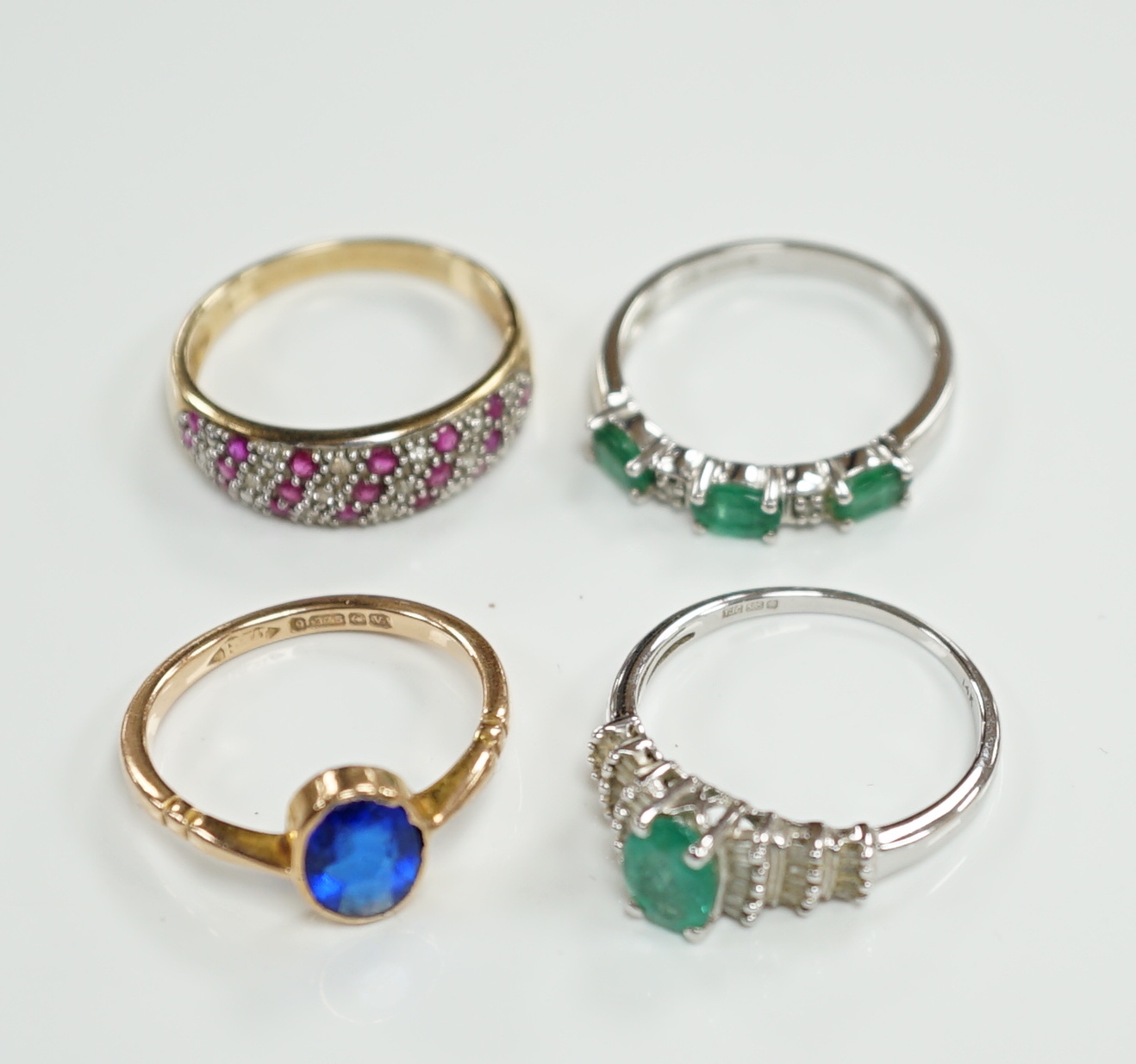 Three assorted modern 9ct gold and gem set rings including emerald and diamond chip set half hoop, size N, gross weight 6.8 grams and a modern14ct white gold and single stone emerald set dress ring, with baguette cut dia